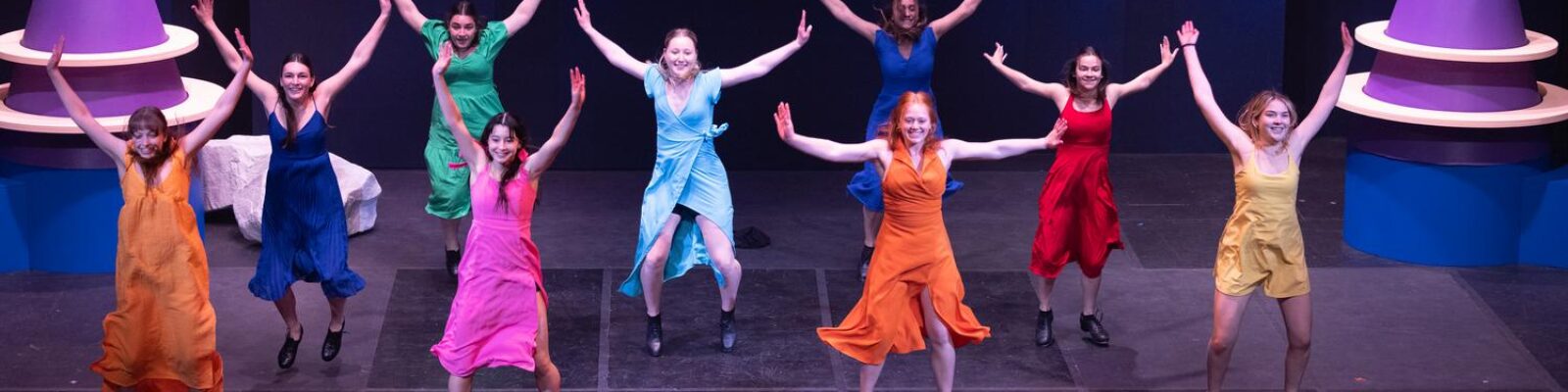 Students dancing in colorful dresses for orientation show
